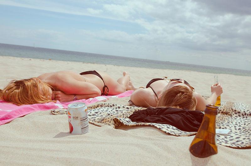 two women laying on the beach