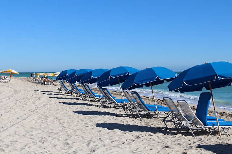 A Beach with blue and yellow umbrellas