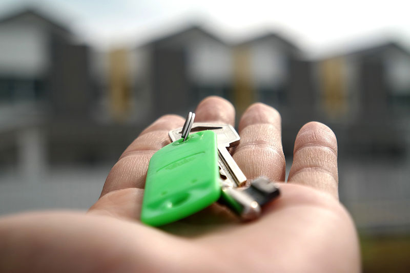 a person holding house keys on their hand showing that moving affects your mental health