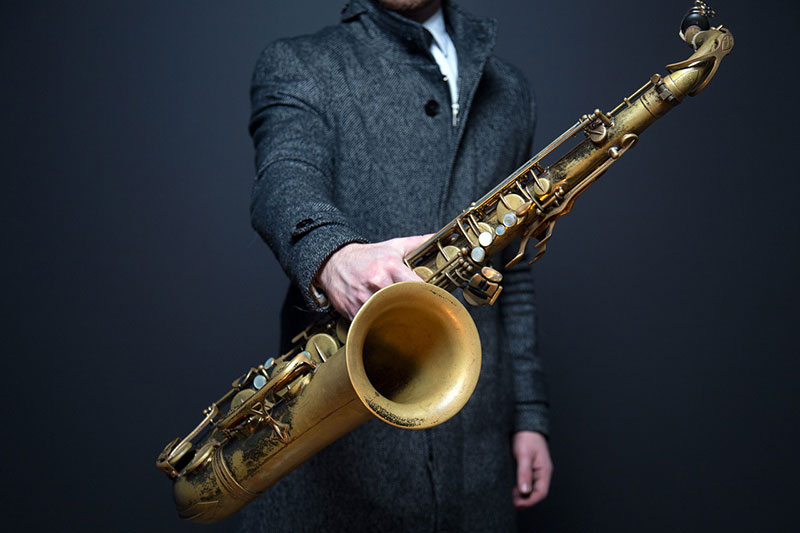 A musician holding at a saxophone.