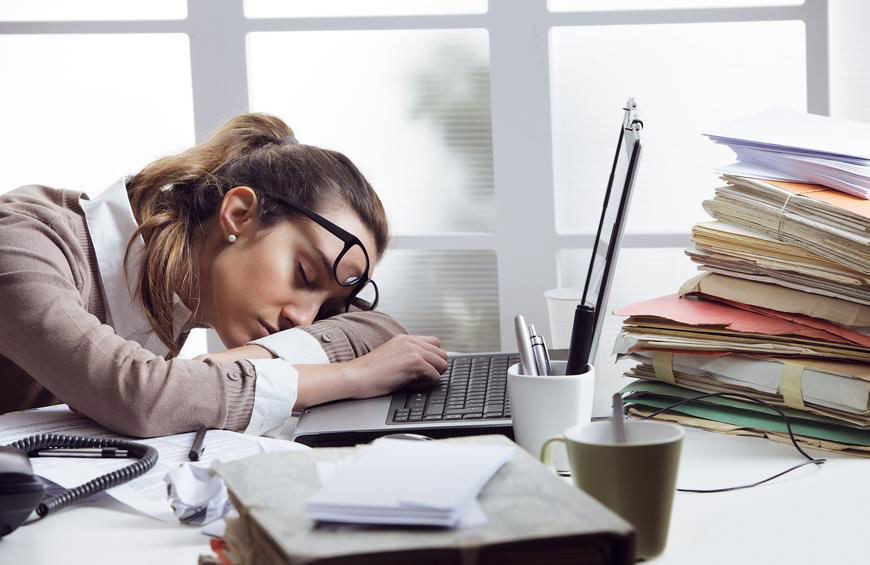 Tired business woman with her head on the desk