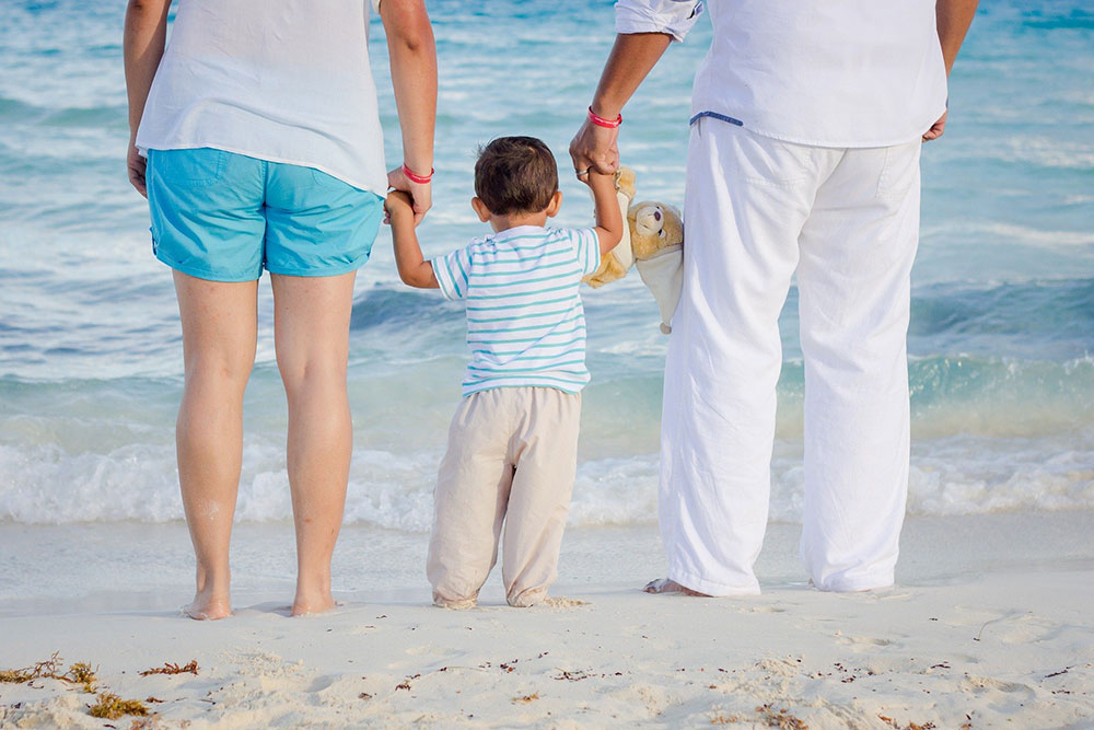 A couple with their kid on the beach