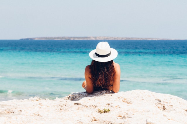 a woman lying on a beach in one of the best summer vacation destinations in Florida 