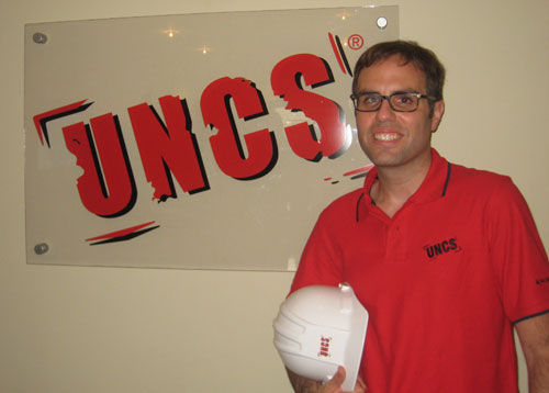 Brett-Rose-with-hardhat-in-front-of-UNCS-sign-101012